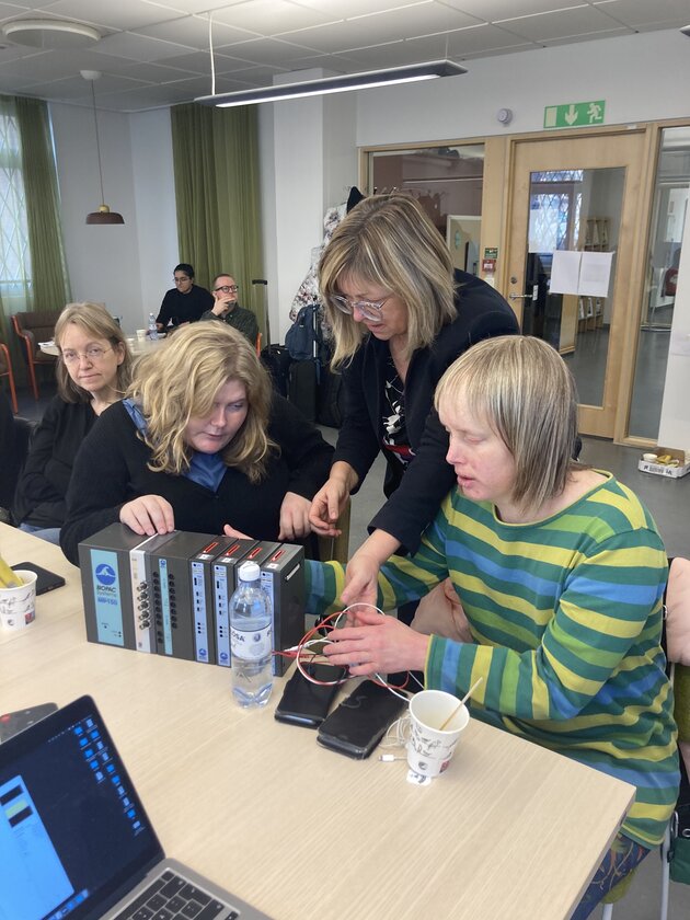 Bildbeskrivning: Jana Holsanova (LU) visar upp BioPac utrustning för Emma och Rakel från Unga med Synnedsättning. Till vänster i bild även samverkansmedlem Anna-Karin (SPSM).